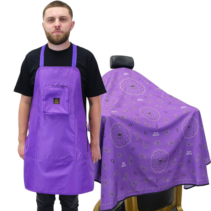 A person wearing a purple barber apron with pockets and a matching purple hair cutting cape with a pattern of what appears to be gears and or gears manes.