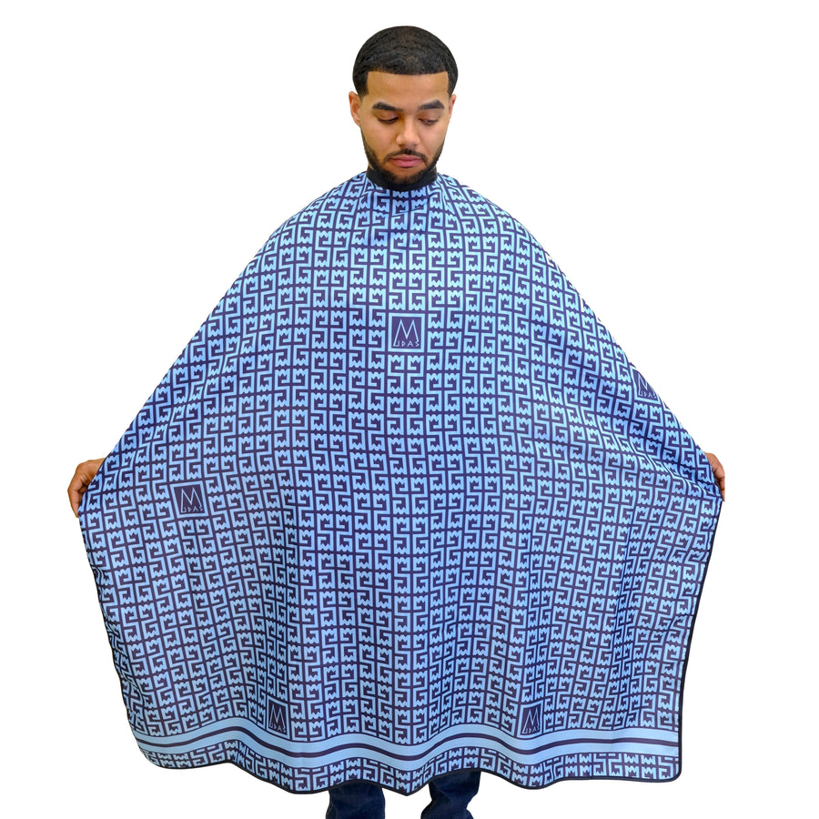 Man wearing a blue patterned barber cape on a white background