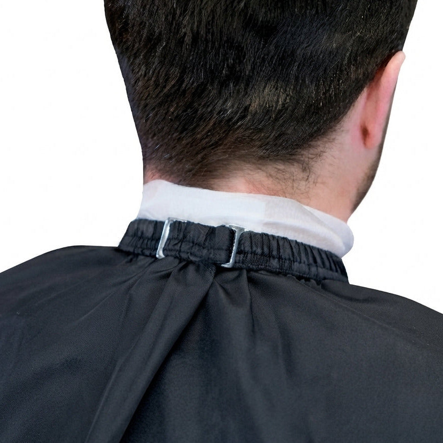 Rear view of a person with short dark hair wearing a black custom barber cape with elastic neck.