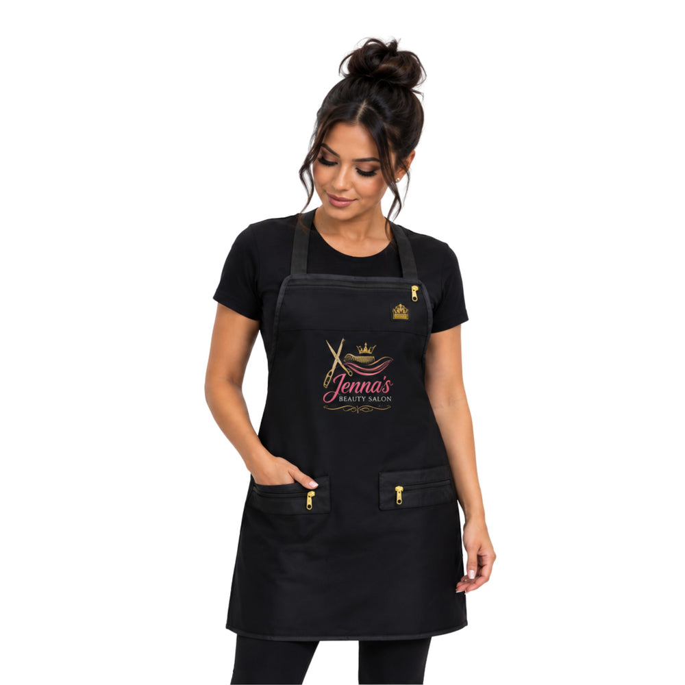 A woman modeling a black salon apron with gold and pink logo personalized hair stylist apron details on the front, featuring a neck strap, waist ties, and two front pockets with gold zippers.