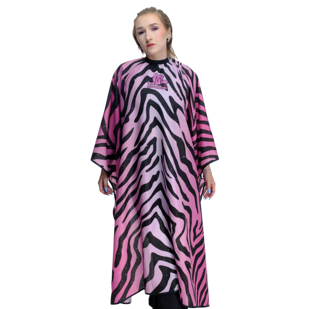 Person wearing a pink and black zebra hair stylist cape with a logo. 
Salon cape - hair stylist cape - zebra print hair stylist cape- pink hair stylist cape