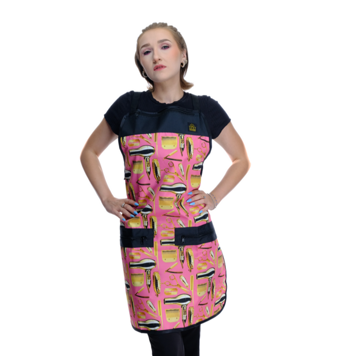 Person wearing a pink hairstylist apron with  hair styling tools patterns on a white background