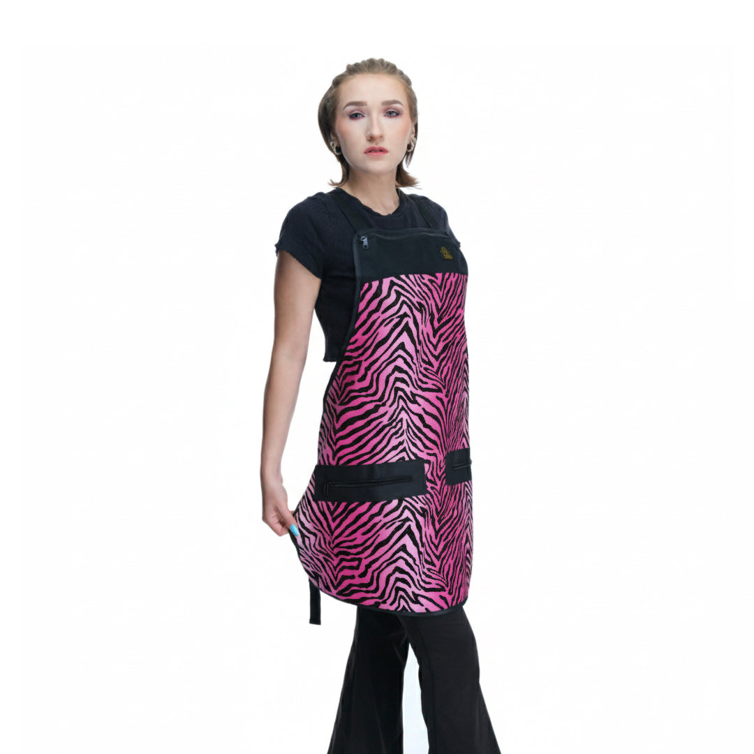 Person wearing a black and pink zebra pattern salon apron on a white background.