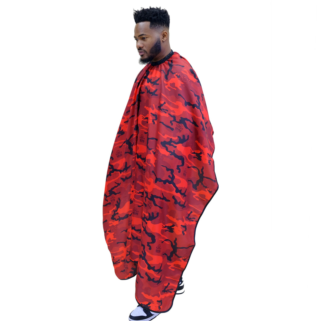Person wearing a red and black camouflage barber cape on a white background