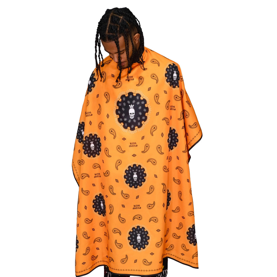 A person modeling a orange bandana barber cape.