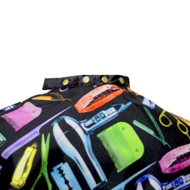 Colorful hair cutting cape with hair styling tools on a black background